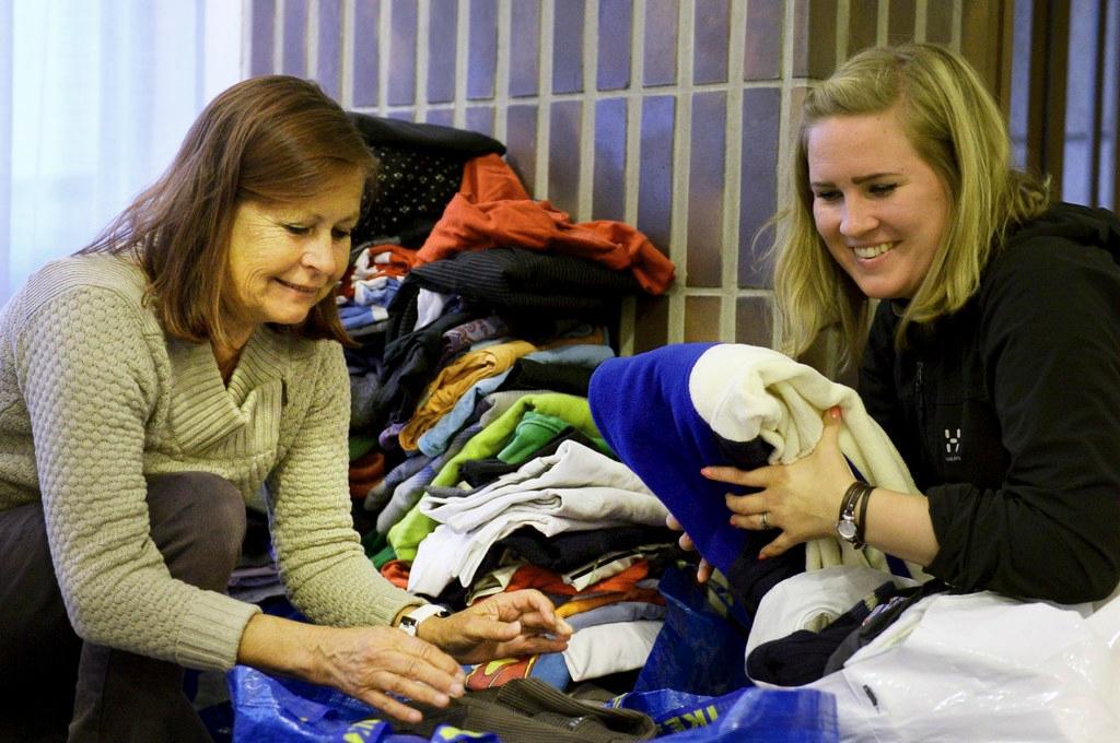 Riitta Salonen ja Marjut Mulari lajittelivat vaatteita Lauttasaaren kirkossa. Kuva: Vesa Moilanen / Lehtikuva