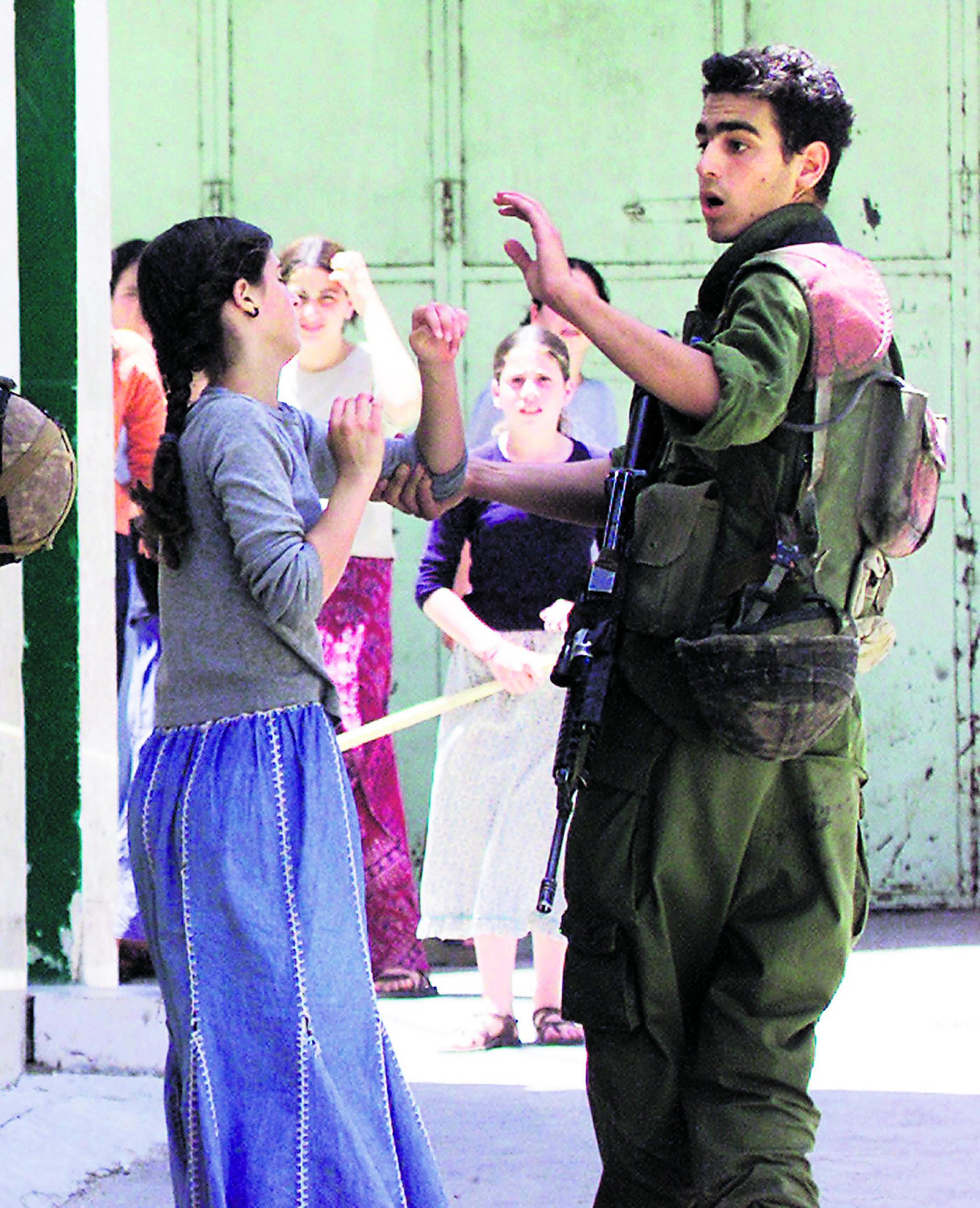 ”Rauha, rauha...” Armeijan sotilas estää israelilaisnaista heittämästä kiveä moskeijaan Hebronissa toisen intifadan aikana 2002. Samana vuonna palestiinalaiset tekivät 47 itsemurhaiskua Israeliin. Rauhan-neuvottelut ovat olleet koko vuosi-kymmenen jäissä.
