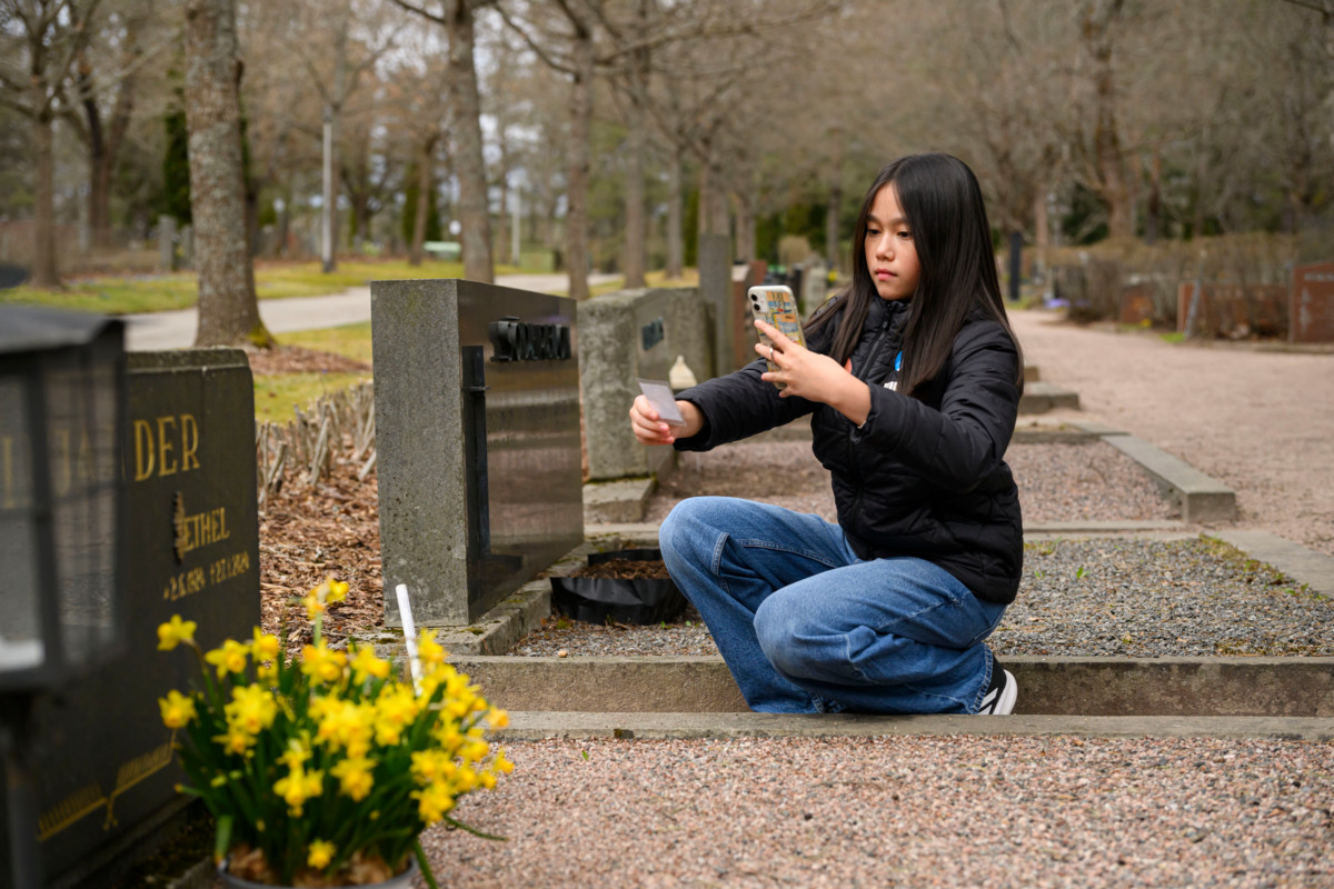 Olivia Houttu ensimmäisellä rastilla. Tehtävänä on löytää mahdollisimman vanha hauta ja kuvata se. 