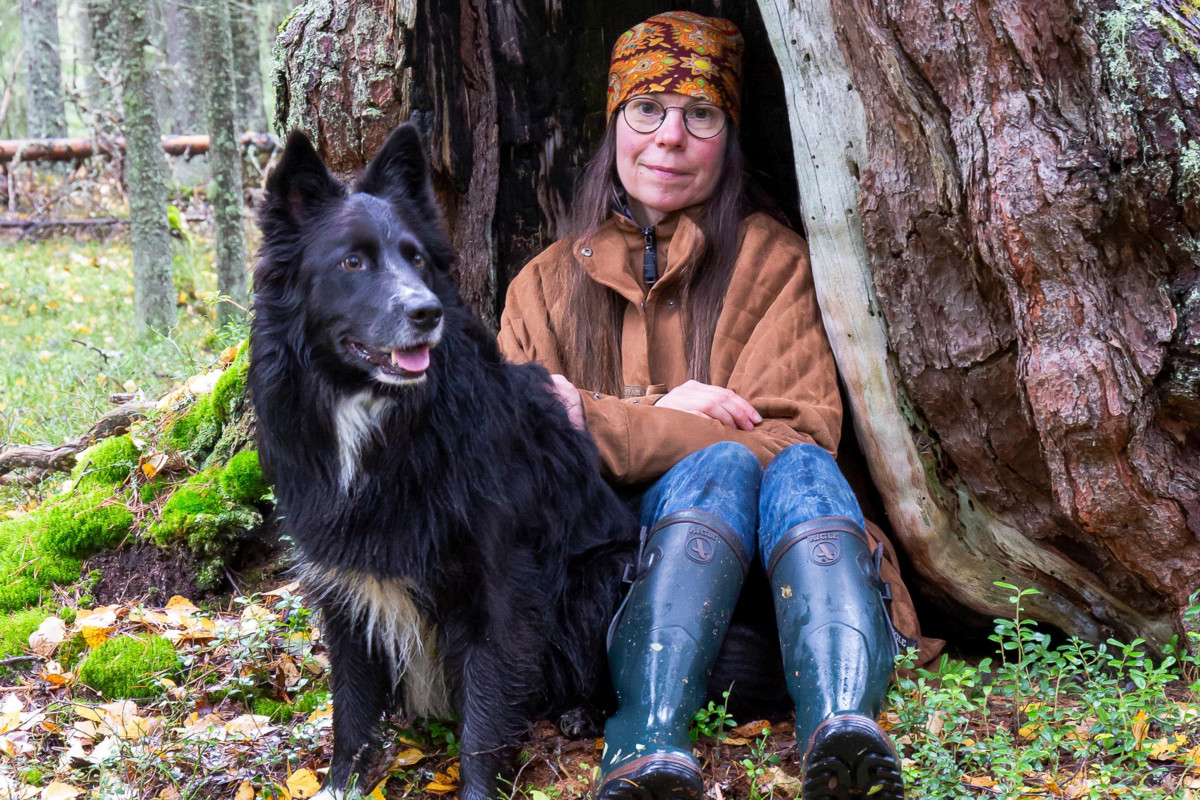 ”Ihmisyyteen kuuluu empatia ja huolenpito, joka kohdistuu muunkin lajisiin olentoihin”, kirjailija Aura Koivisto sanoo. Hän elää Kainuun metsien keskellä miehensä ja koiransa kanssa. Kuvan Musti kuoli viime talvena. Kuva: Risto Sauso