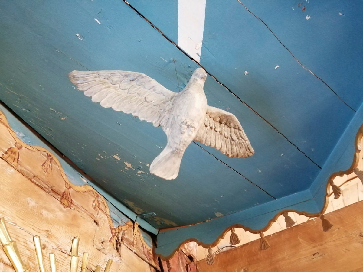 Kyyhky liitelee saarnastuolissa. Kuva: Sari Karvonen/Kempeleen seurakunta