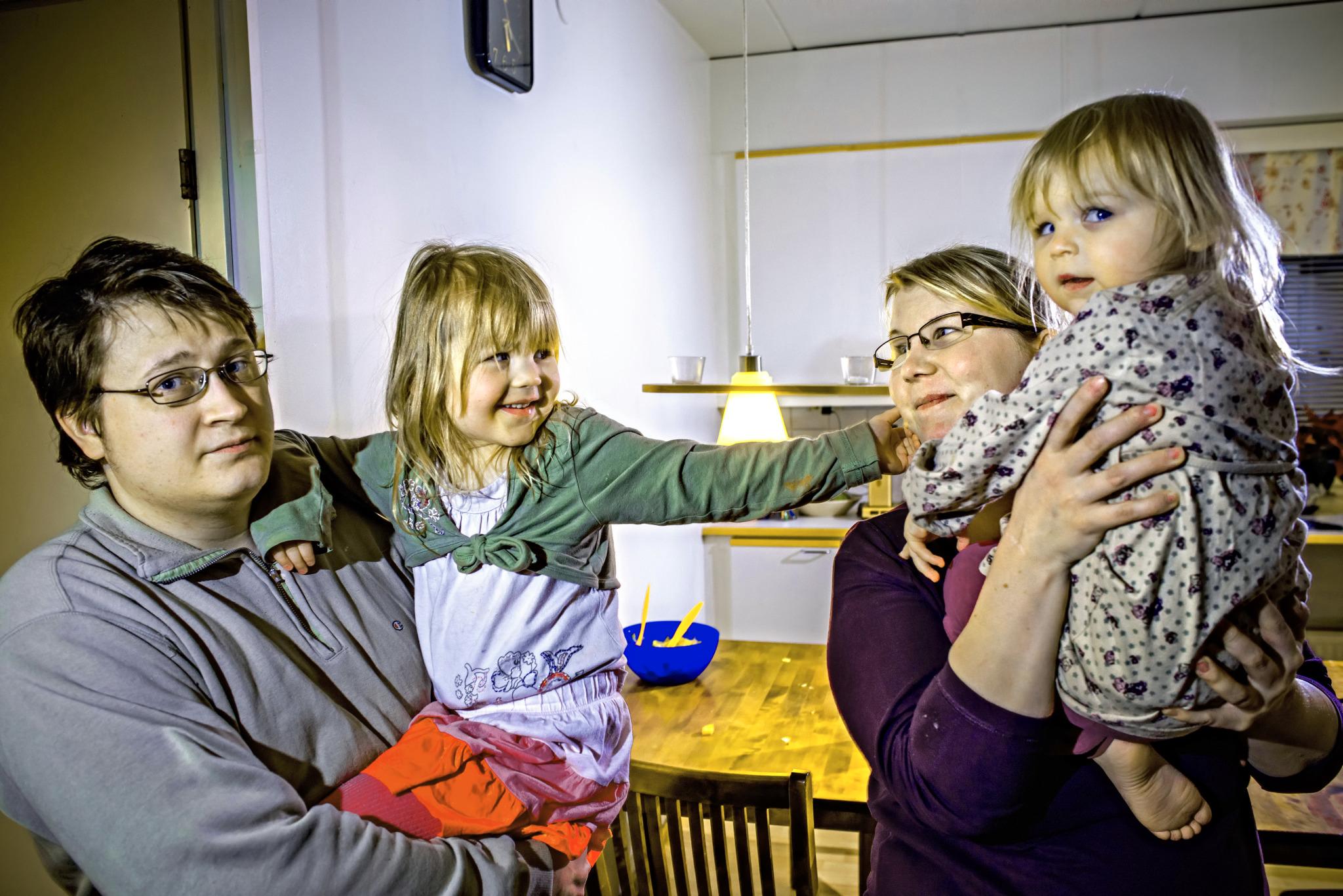 Mika Riekki ja Kirsi Hokkinen ovat opettaneet lapsille, että lautaselle ei kannata ottaa liikaa ruokaa. Vanhempien sylissä 4-vuotias Sonja ja 2-vuotias Milla. Kuva: Hans von Schantz
