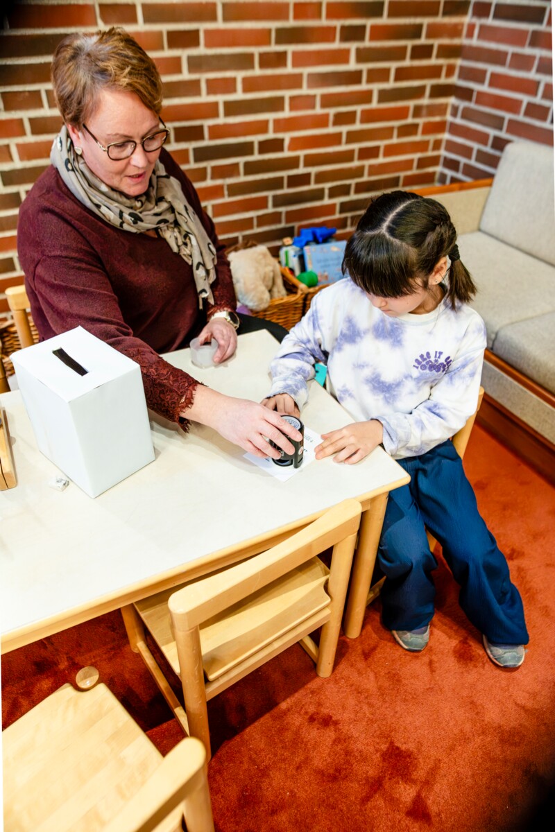 Maisie Särkkä harjoitteli äänestämistä Malmin kirkolla. Varhaiskasvatuksen johtaja Johanna Laurinen leimasi äänestyslipun.