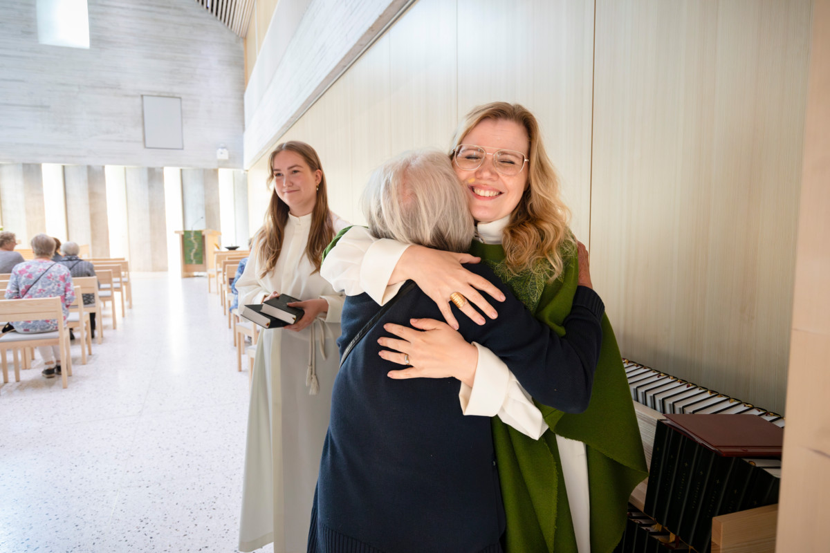 Pappi Johanna Jakonen ja messuavustaja Matilda Hoviniemi toivottavat seurakuntalaiset tervetulleiksi messuun Tikkurilan kirkkoon. Kuva on elokuulta 2024.