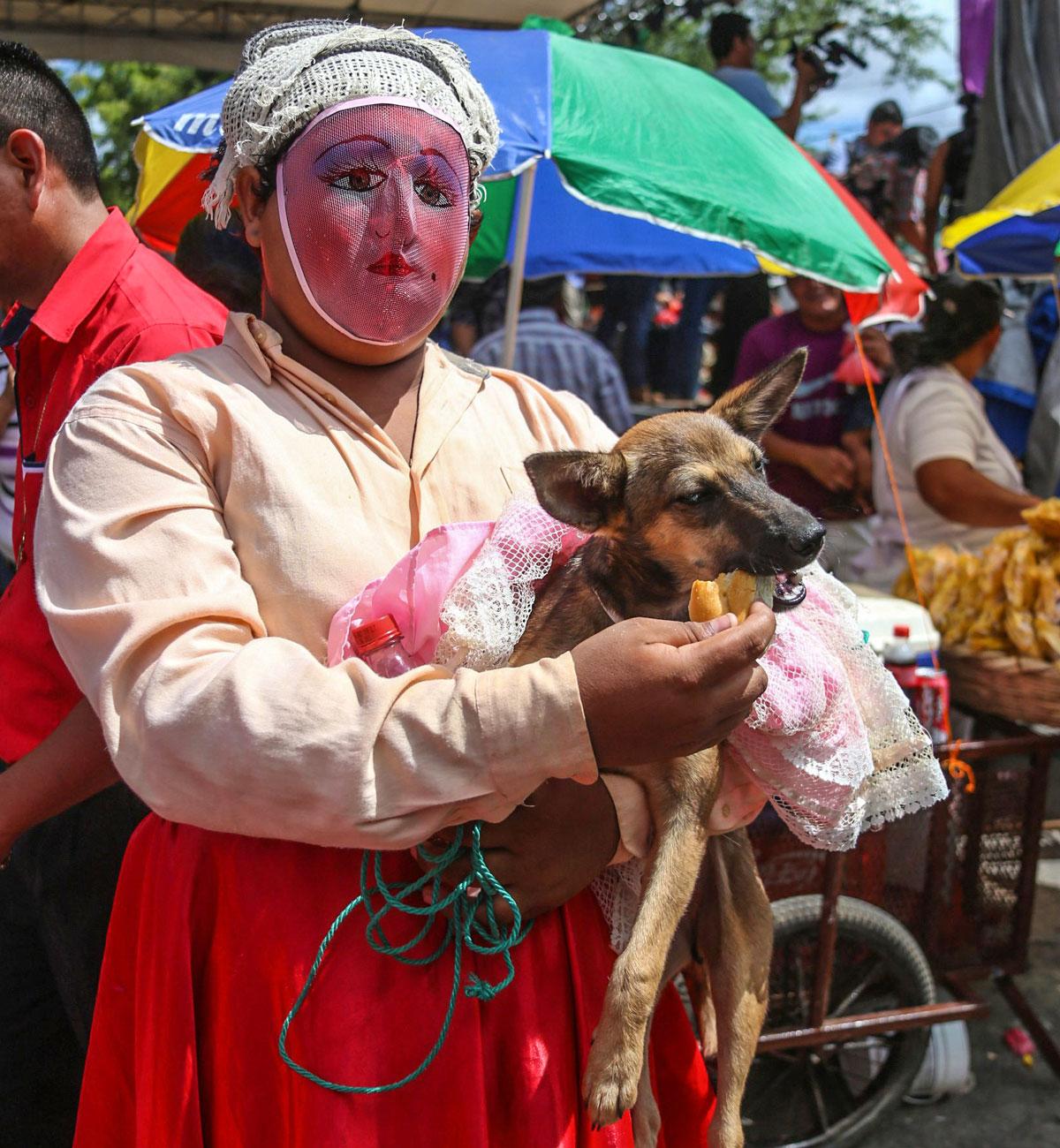 Perinnetanssija ruokkii koiraansa Pyhän Lasaruksen -festivaalilla Monimbon lähiössä Masayan kaupungissa Nicaraguassa. Täällä Lasarusta kunnioitetaan muun muassa pukemalla lemmikkikoirat. Festivaali koostuu aamumessusta, jossa ihmiset pyytävät Lasarukselta koirilleen siunausta sekä ihmeitä heidän perheilleen ja ystävilleen. Juhliin kuuluu myös kisa, jossa parhaiten pukeutunut koira palkitaan. Tänä vuonna koirien kostyymikinkerit järjestettiin 7. huhtikuuta. Nicaragualaisille juhla on osa pyhää viikkoa (semana santa), jota juhlitaan pääsiäisen lähestyessä.