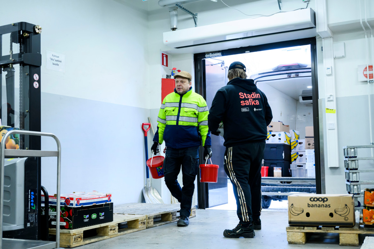 Stadin safkan logistiikkakoordinaattorit Mikko Kotavuo (vas.) ja Emppu Säyriö purkavat aamulla noudetut hävikkiruoat ja -tarvikkeet Stadin safkan terminaaliin, jossa ne lajitellaan eteenpäin asiakkaille vietäviksi.