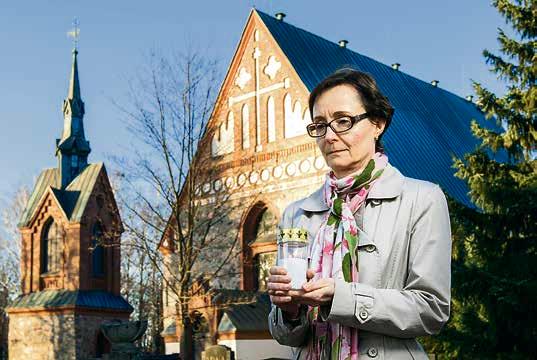 Maarit Ekokoski vie haudoille kynttilöitä.