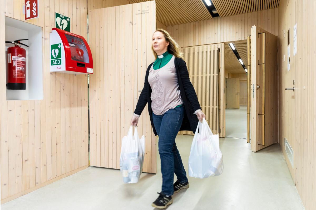 Diakonissa Pauliina Alanko kantaa diakonian asiakkaille osoitettuja ruokakasseja.