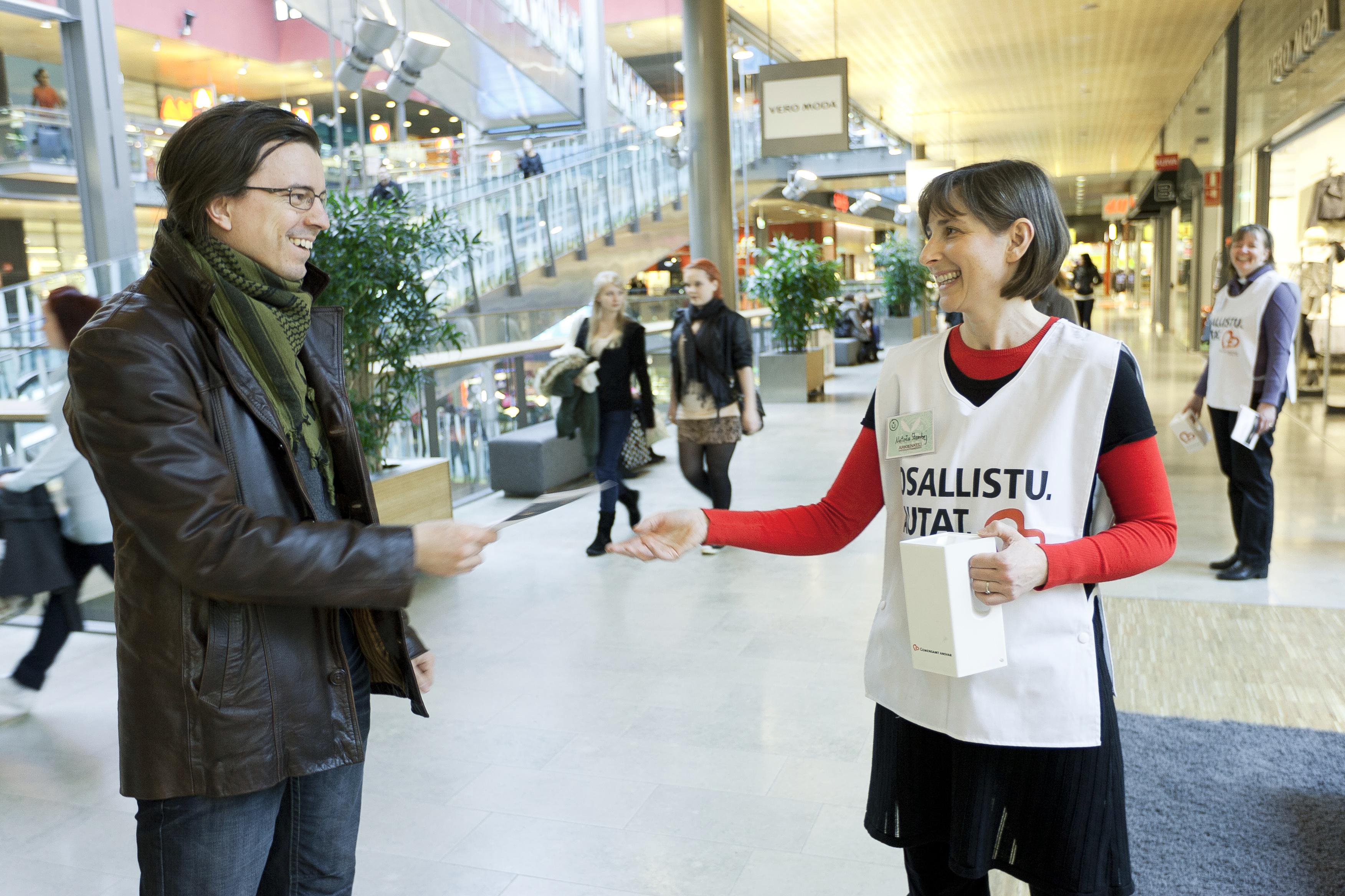 Antero Saksa löysi sopivasti taskustaan kolikon Nataša Stambejin (oikealla) keräyslippaaseen pudotettavaksi.