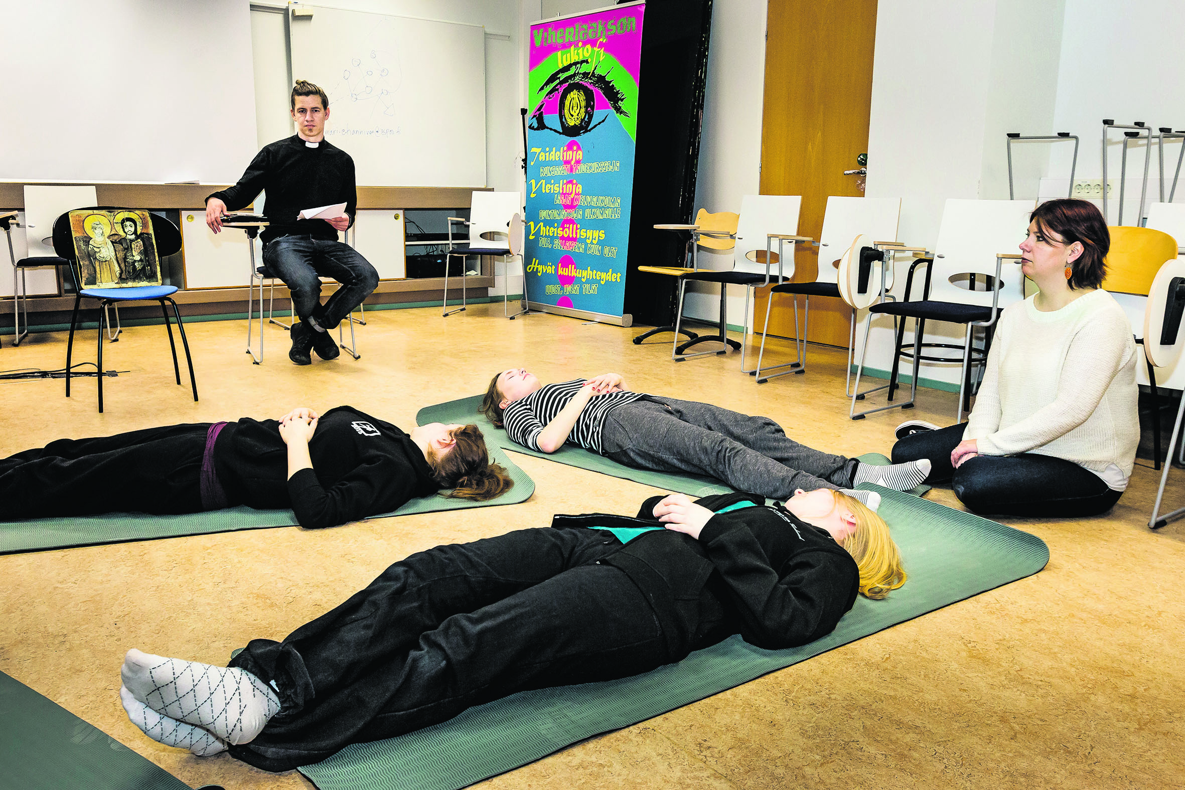 Ennen koetta. Abit Krista Sjöman, Ella Jokela ja Ida-Maria Keisala sekä opettaja Sari Autio Antti Siukosen vetämässä meditatiivisessa rukoushetkessä.