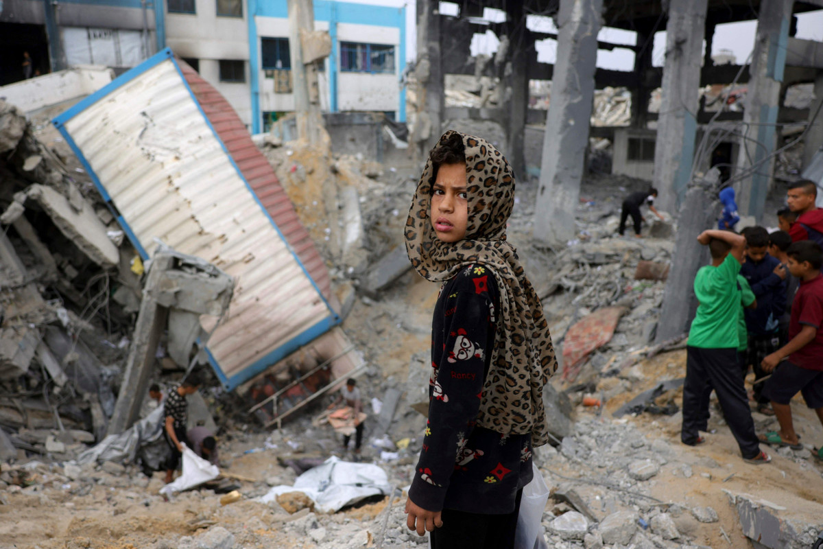 Palestiinalaistyttö seisoo entisen koulun ja väestönsuojan raunioiden luona Gazassa. Jabaliassa sijaitseva rakennus tuhoutui Israelin iskussa. Kuva: Bashar Taleb/AFP/Lehtikuva. 