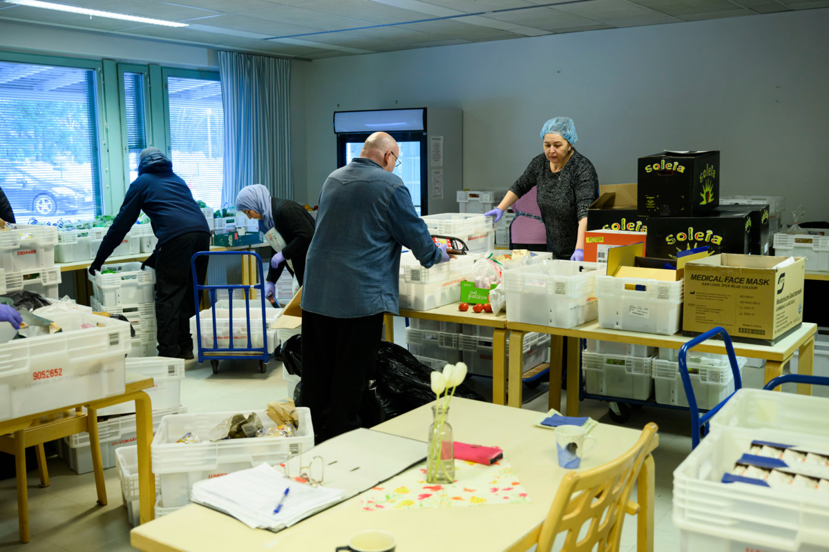 Vapaaehtoiset lajittelevat juuri tulleita hävikkituotteita ruokajakoa varten. Oikealla keittiön vastaava Volga Baeder. ”Sydäntäni lämmittää se, miten ihmiset täällä haluavat tehdä hyvää toisille.”