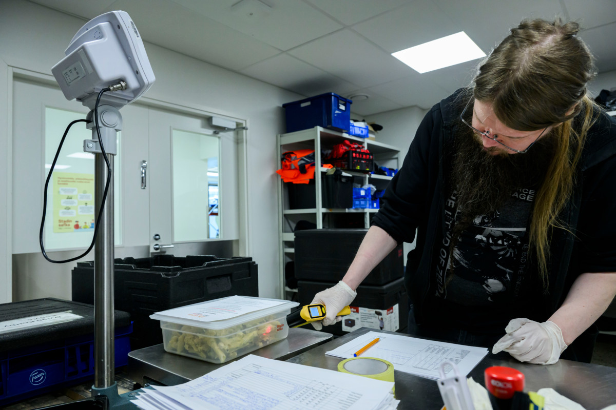 Logistiikkakoordinaattori Tony Lahtinen mittaa aamulla noudettujen, lounaslinjastoilta yli jääneiden hävikkiruokien lämpötilan ja samalla punnitsee määrän Stadin safkan terminaalissa. Lämpötilan täytyy olla alle yhdeksän astetta, jotta kylmäketju on kunnossa. Lahtinen myös kirjaa ruokien tiedot jakolistaan, minkä perusteella ne toimitetaan eteenpäin.