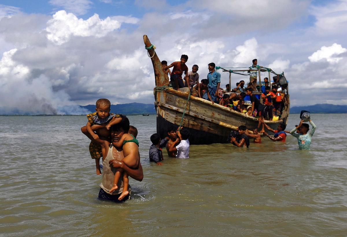 Nämä väkivaltaa pakenevat rohiyanga-muslimit pääsivät veneellä pakoon Bengalinlahden yli Bangladeshiin. Myanmarin puoleisella rannalla näkyy savua.