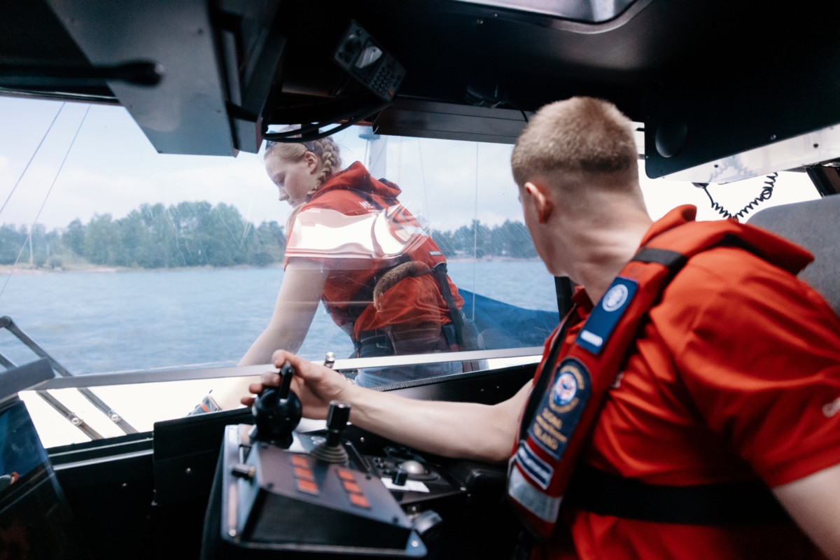 Mortti Aittokoski seuraa puikoista, kun Sally Kurppa kiinnittää purjevenettä pelastusveneen kylkeen. Pelastusvenettä pitää ajaa samaa tahtia köyden mitan päässä ajelehtivan purjeveneen kanssa, jotta kiinnitys onnistuu. 