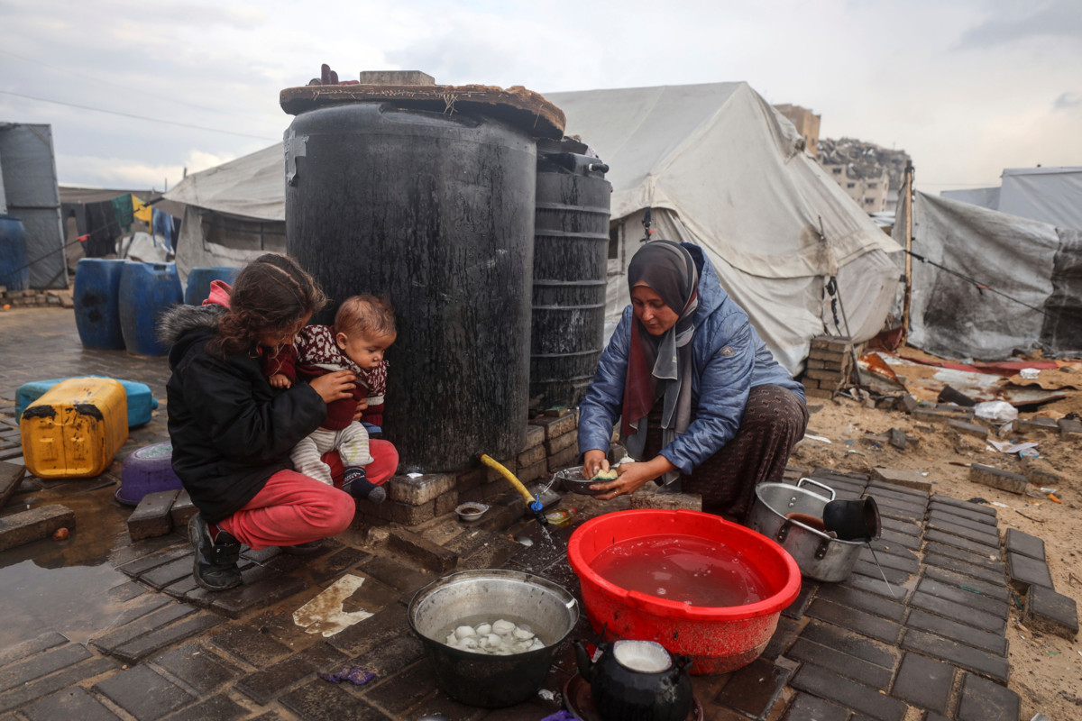 Nainen pesi astioita käsin Gazan kaupungissa 10. joulukuuta 2025 rankkasateiden jälkeen.