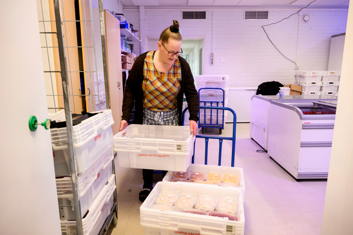Jaana Korvola siirtää kärryillä varaston kylmiöstä aamulla tulleet ohrapuurot ja mehukeitot ruokajakopisteelle ulos juuri ennen jaon alkamista.