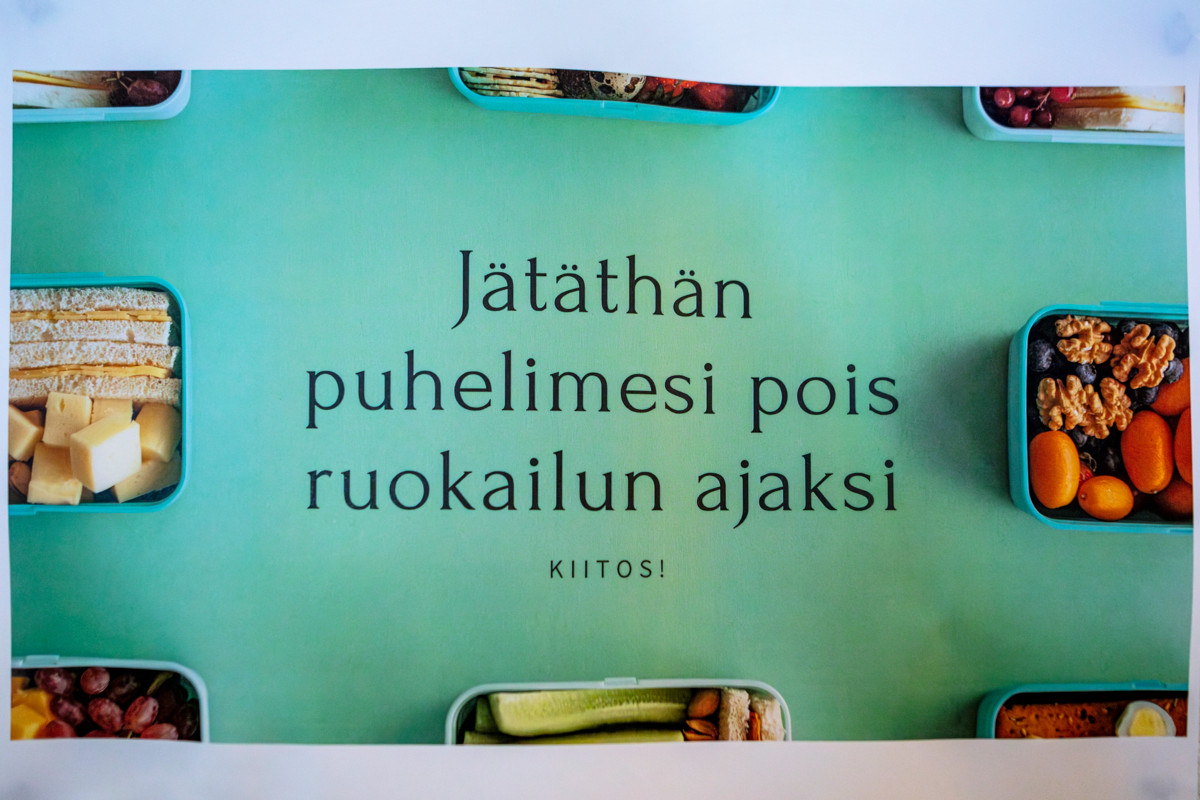 Syömisen aikana ei vilkuilla kännykkää, muistuttaa ohje ruokailutilan seinällä.