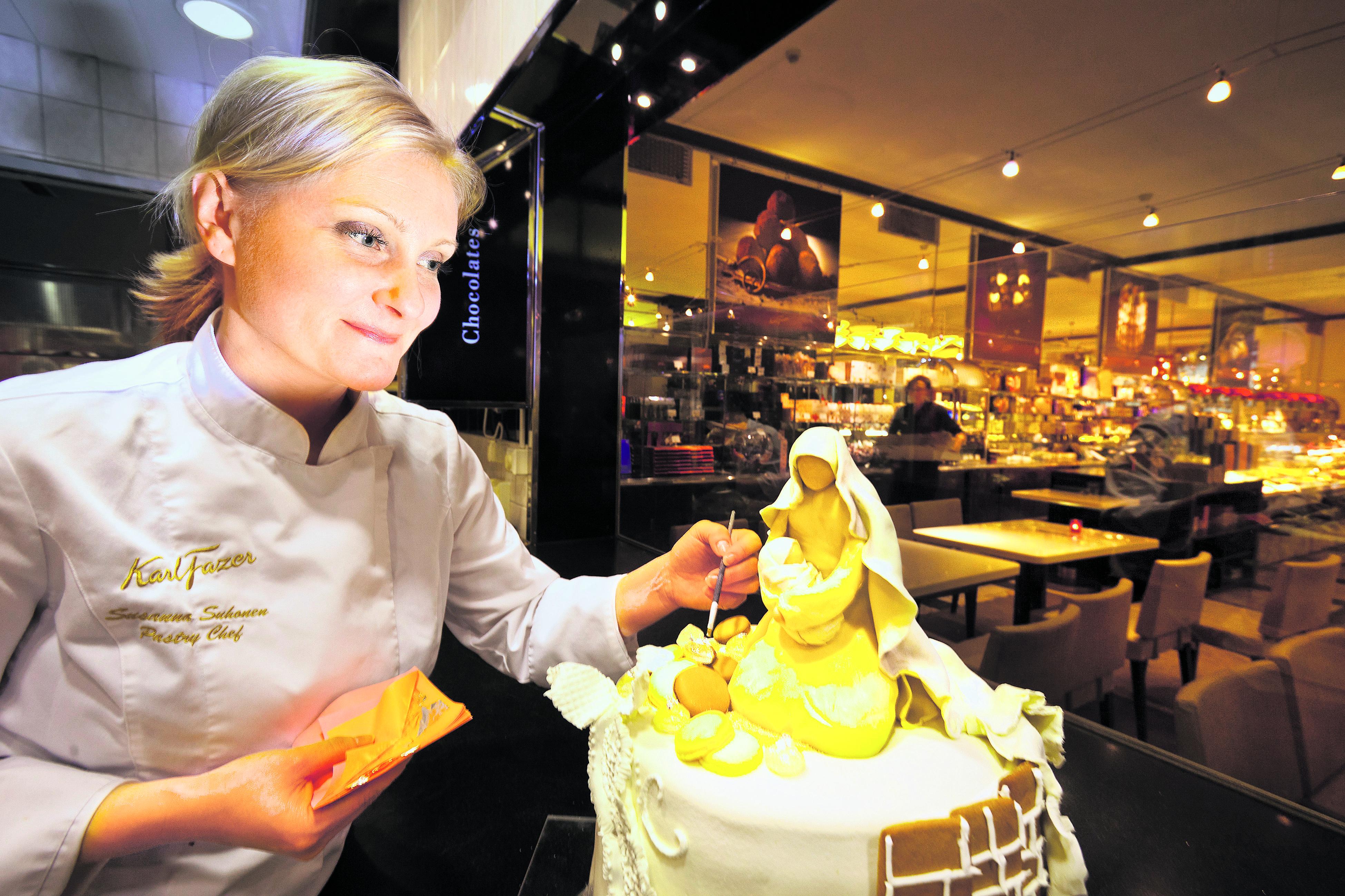 Tutut hahmot. Susanna Suhonen viimeistelee suunnittelemaansa jouluseimeä Kluuvin Fazerilla. Seimeä voi ihailla jouluun asti kahvilan ovensuussa.