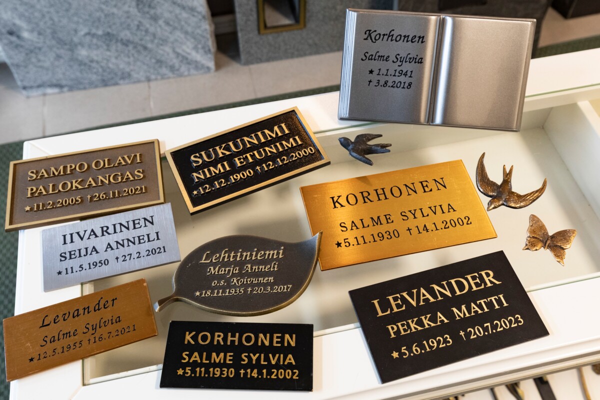 Metalliset nimilaatat hautakivissä ovat yleistyneet uurnahautausten myötä.