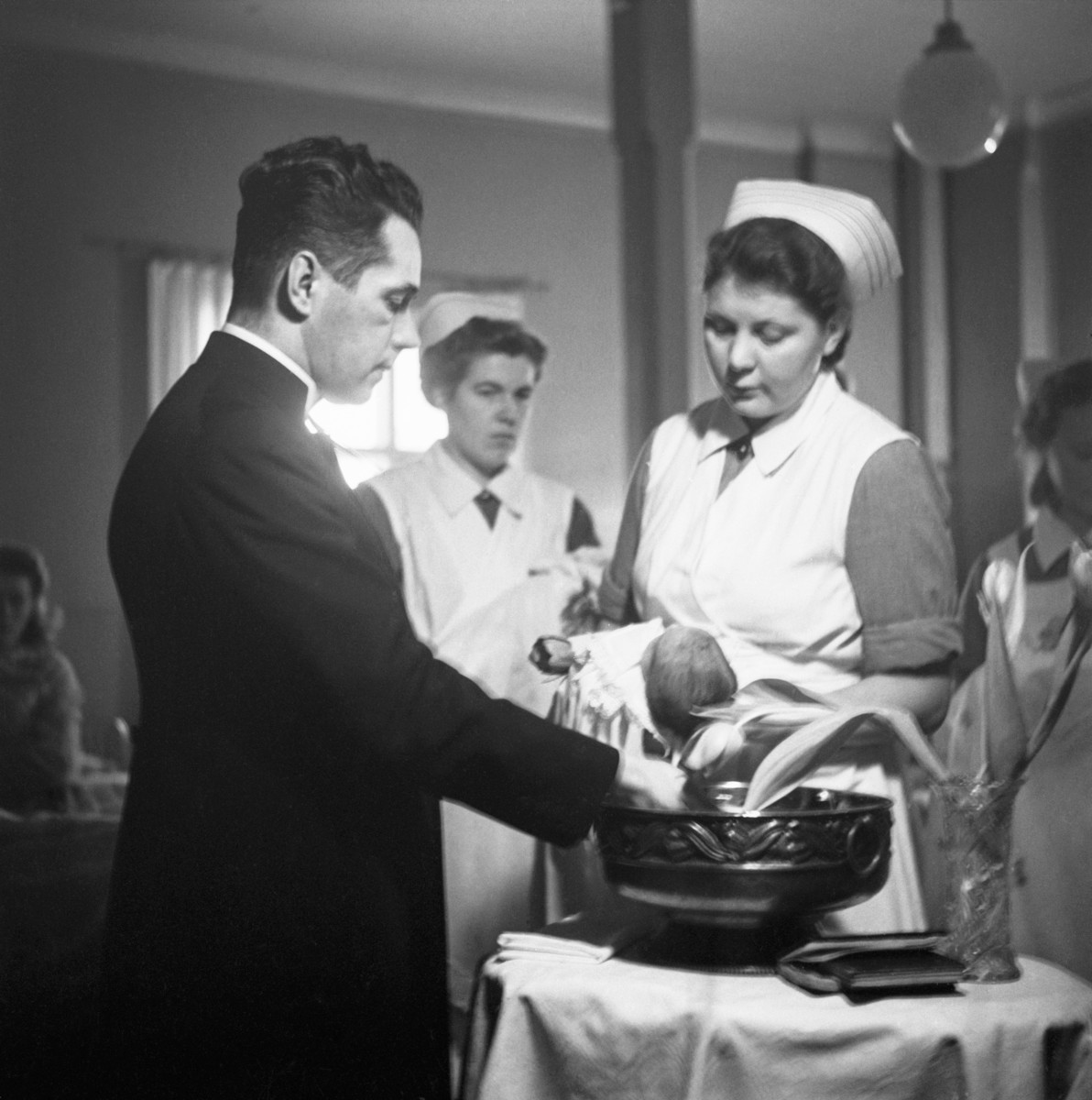 Lapsi kastetaan Kätilöopistolla vuonna 1947. Kuva Museovirasto / JOKA Journalistinen kuva-arkisto / UA Saarisen kokoelma