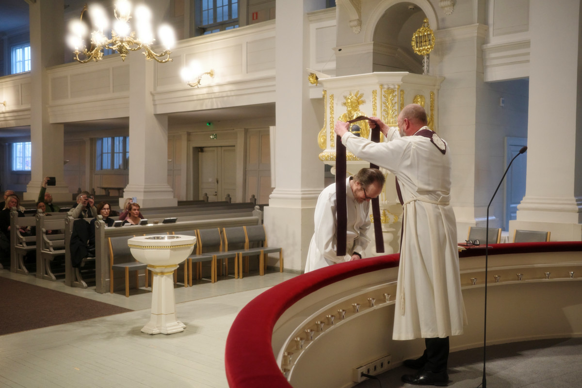 Piispa Teemu Laajasalo asetti stolan Kai Sadinmaan hartioille Vanhassakirkossa 26. maaliskuuta. Tuomiokapituli päätti Sadinmaan pappisoikeuksien palauttamisesta edellisenä päivänä. Kuva: Heikki Nenonen.