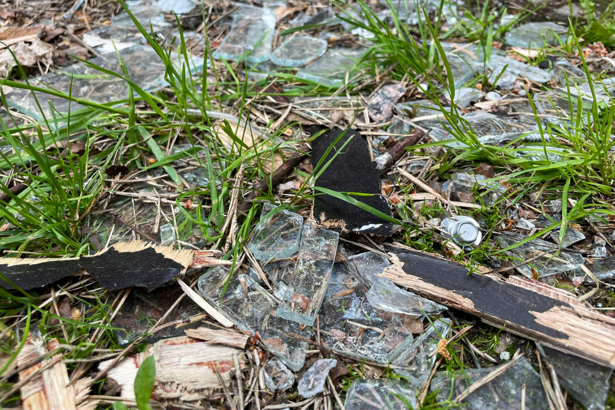 Kirkon pihanurmella on rikottujen ikkunoiden siruja.  