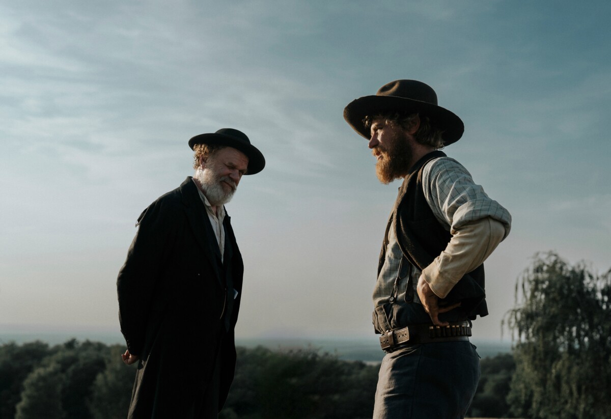 Pikkukaupungin lääkäri (John C. Reilly) ja sheriffi-pappi (Johnny Flynn) joutuvat raskaiden valintojen eteen A Prayer for the Dying -elokuvassa.