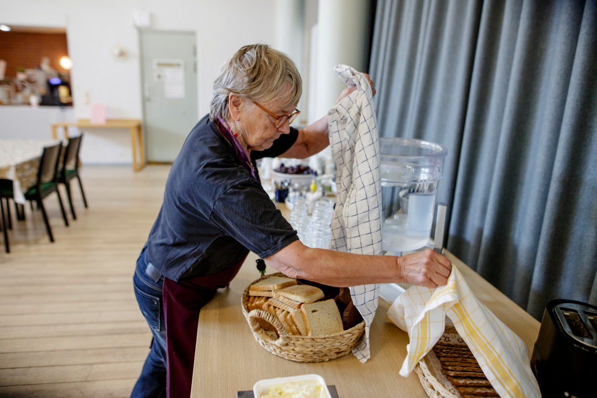 Vapaaehtoinen Marja Smulovitz valmistelee ruokasalin lounastarjoilua.