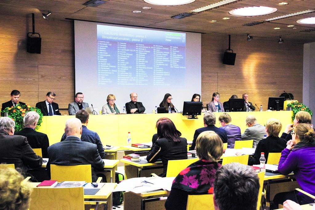 Kops! Yhteisen kirkkovaltuuston kokouksessa nuijtaan läpi seurakuntien päätöksiä. Luterilaisuudessa maallikot ja papit päättävät kirkon asioista yhdessä, mutta käytännössä papistolla on viimeinen sana.