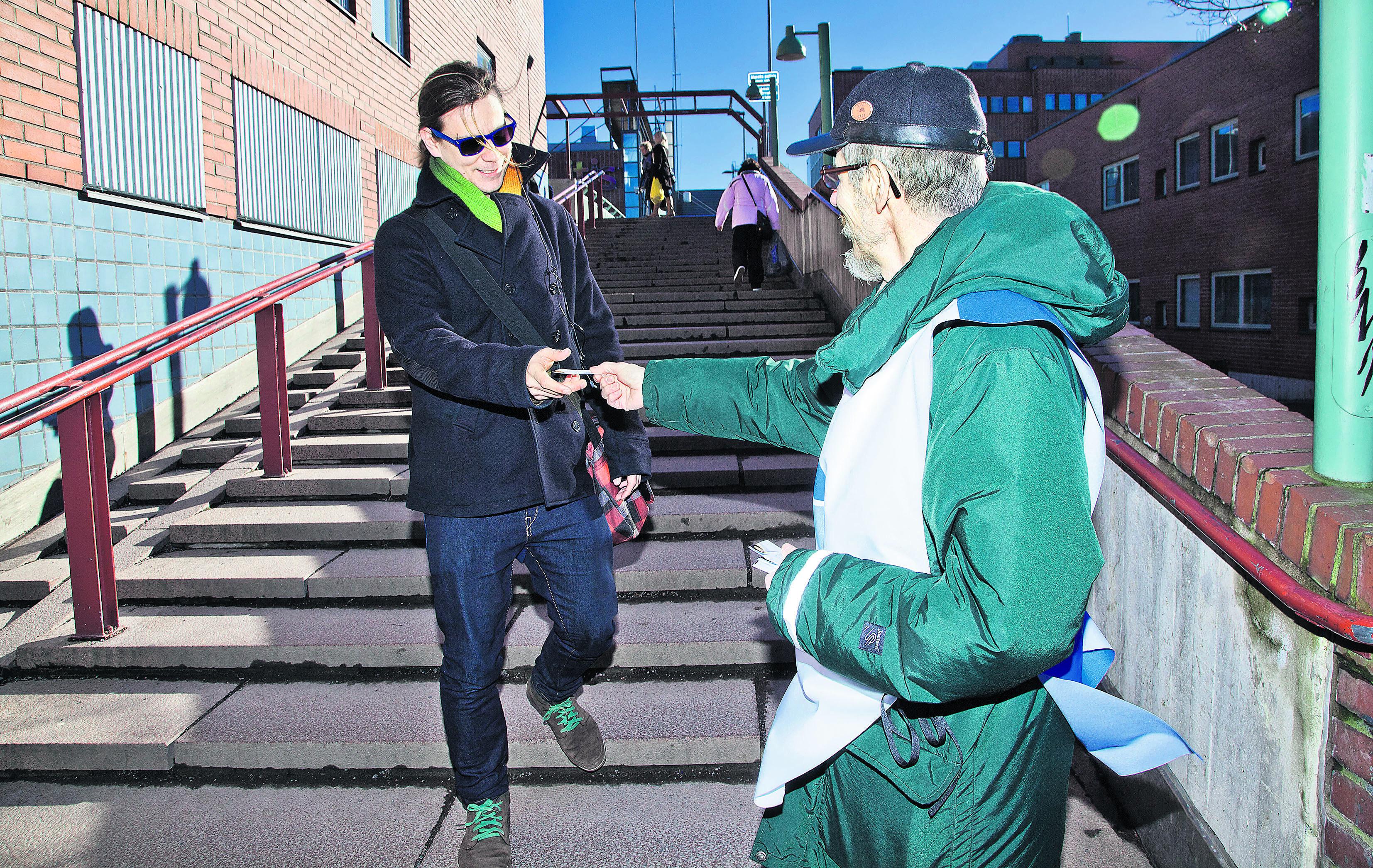 Tervetuloa. Seurakunnat varautuvat tiukkenevaan talouteen muun muassa toimintamäärärahoja leikkaamalla. Samalla etsitään uudenlaisia toimintamuotoja. Kuvassa seurakunnan vapaaehtoinen jakaa kutsuja ilmaisille kahveille, jotka tarjoiltiin Matteuksenkirkon pihalla Itäkeskuksessa.