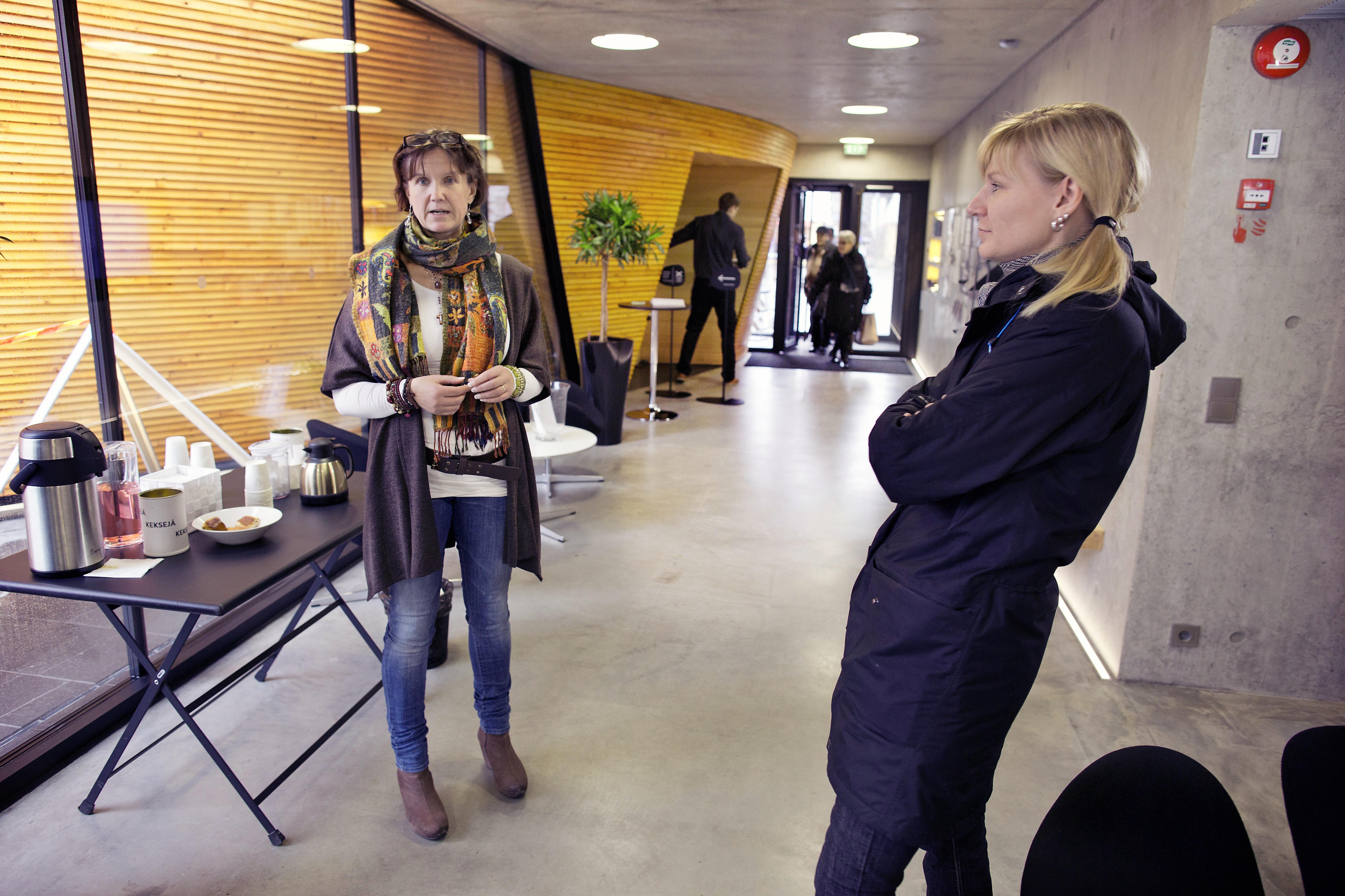 Toiminnanjohtaja Tarja Jalli ja nuorisotyönohjaaja Taija Elste kohtaavat ihmisiä Kampin kappelin aulassa. 