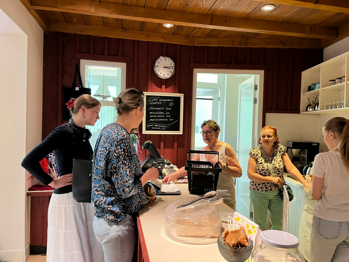 Mansi Cozijn ja Jasja Blanken ruokaostoksilla Rotterdamin merimieskirkolla. Tiskin takana heitä palvelevat vapaaehtoiset Tuula Aho, Sanni Halla-aho ja Lumi Koivisto. Kuva: Kaisa Halonen