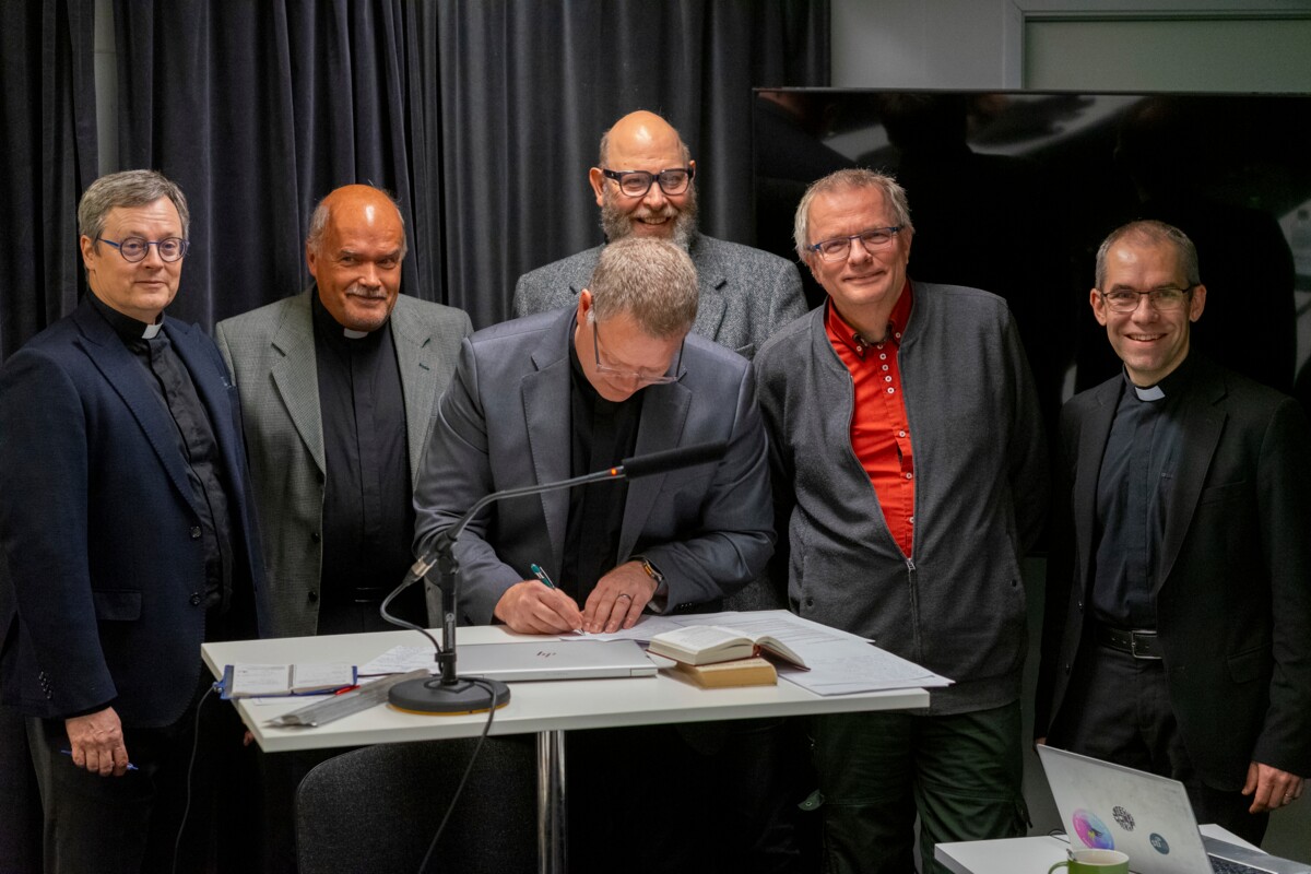 Kirkkokansan liiton jäsenjärjestöjen johtajat ryhmäkuvassa. Kuvassa vasemmalta Tom Säilä, Stig-Erik Enkvist, Daniel Nummela (allekirjoittamassa), Lauri Vartiainen, Timo Laato ja Albert Häggblom.