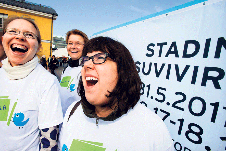 Ääni auki. Vartiokyläläiset Annika Ekelund (oik.), Helena Huttunen ja Helena Ala-Passi harjoittelivat suvivirttä Kampissa jo hyvissä ajoin leijonajuhliin kiirehtivien iloksi. Kuva: Esko Jämsä