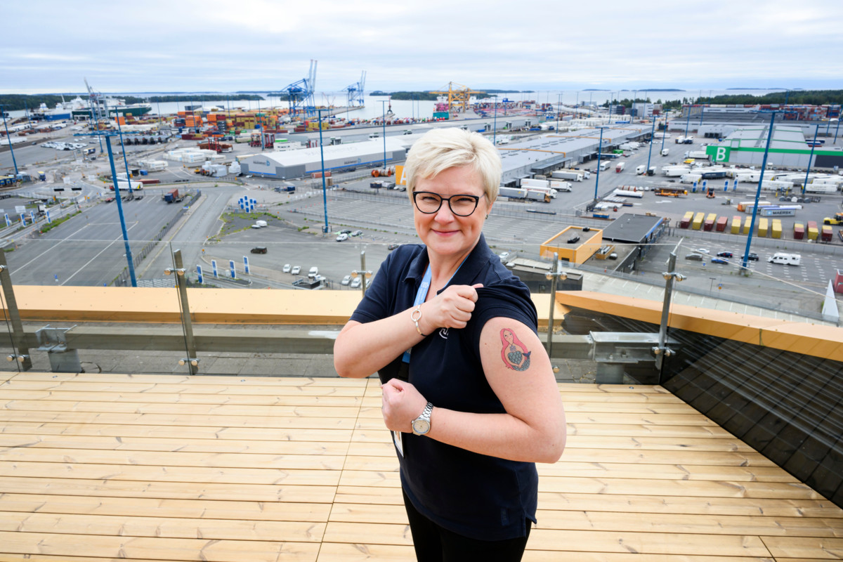 Vuosaaren merimieskirkon satamakuraattori Taija Kivistö näyttää merenkäyntiaiheista siirtotatuointia, jollaisia he tekevät halukkaille Vuosaaren sataman Satamapäivänä.