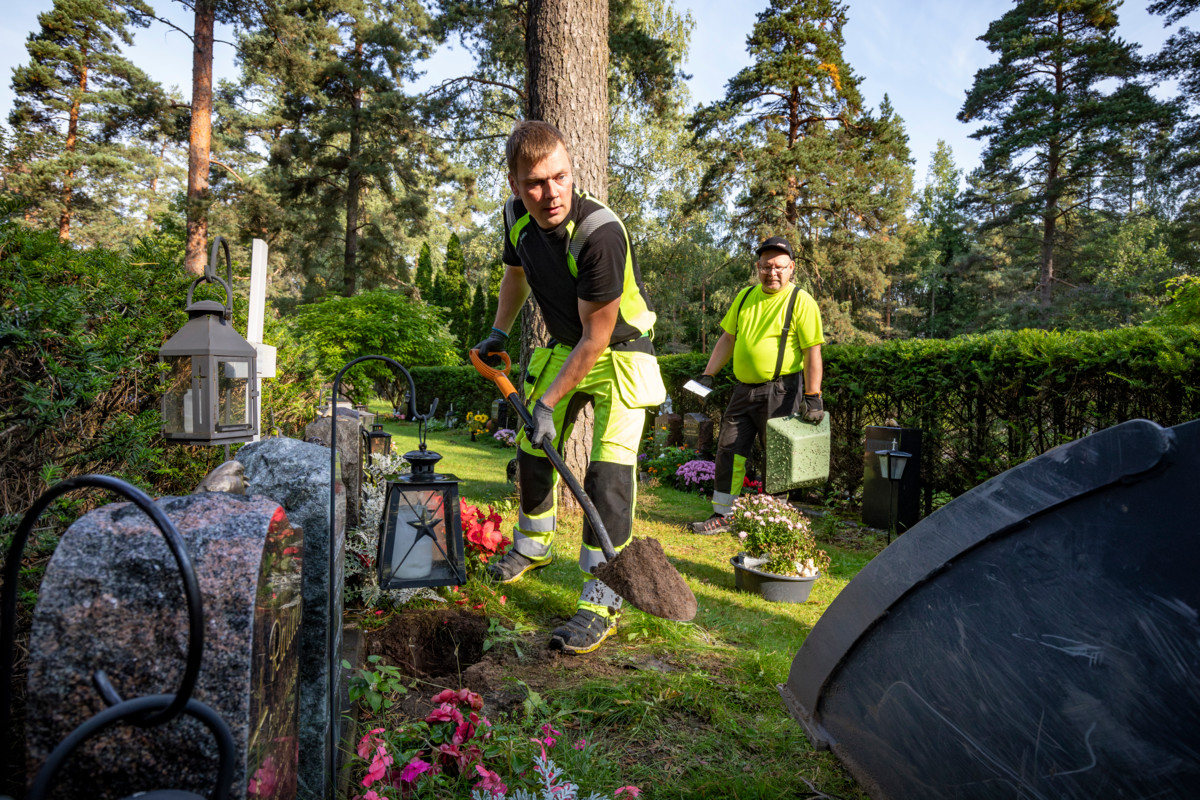 Hautausmaamestari Arttu Hirvonen kaivoi uurnahautaa, taustalla hautausmaamestari Tuomo Rajala.