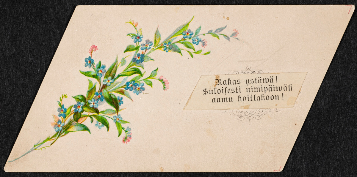 Suunnikkaan muotoinen kortti 1800-luvun lopulta, jossa on kultakirjaimin painettu nimipäiväonnittelu ja lemmikkikimppu. Kuva: Helsingin kaupunginmuseo.