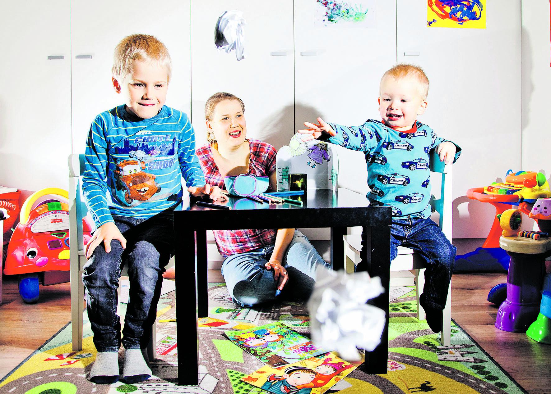 Huolet pois. Tuukka (vas.) ja Niklas Kammonen heittävät paperille piirtämänsä huolenaiheet rypistettyinä pois. Samalla tavalla omat huolet voi antaa Jumalan kannettavaksi. Äiti Minna Kammonen ohjaa taustalla poikiensa pyhäkouluhetkeä.