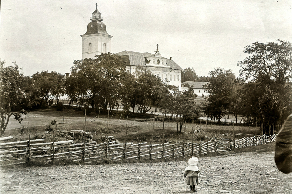 Mustasaaren kirkko (Korsholms kyrka) ja nuori seurakuntalainen. Kuva on ajanjaksolta‎ 1890–1920. Kuva: Svenska litteratursällskapet i Finland.