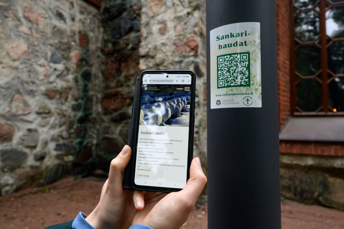 Helsingin pitäjän kirkon hautausmaan ulkolamppujen kyljestä löytyy Toivon puutarha -tarroja, joiden QR-koodin takaa avautuu teksti.