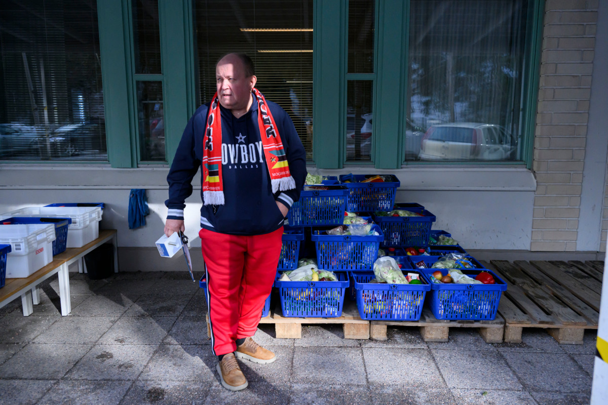 Risto Lyytinen odottelee avuntarvitsijoiden saapumista pihalla, jossa hän tervehtii jokaista jonossa yksitellen. Lyytisellä on kädessään keräyslipas, johon osa kävijöistä sujauttaa rahaa. 