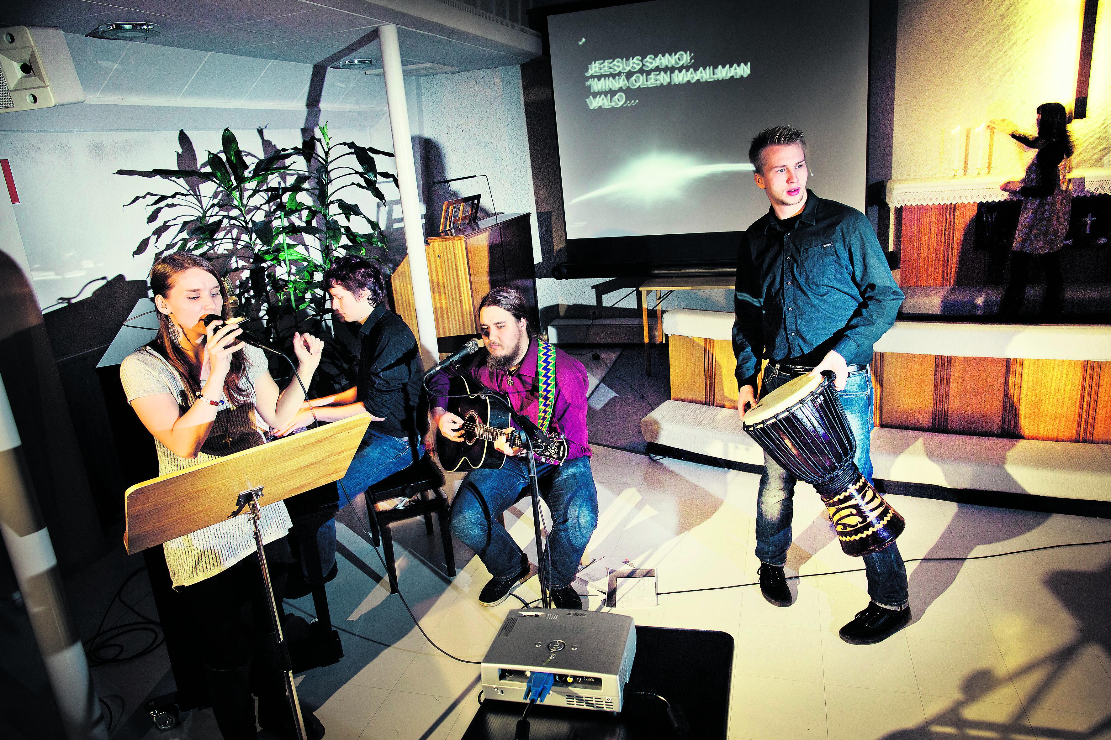 Treenit. Musiikilla on Valon messussa suuri rooli, ja se saa kävijöiltä kiitoksia. Karin Isokoski (vas.), Niko Laasonen, Tapio Leinonen ja Leevi Lönnrot harjoittelevat illan ohjelmaa. Tiina Mäki-Arvela sytyttää kynttilöitä taustalla.