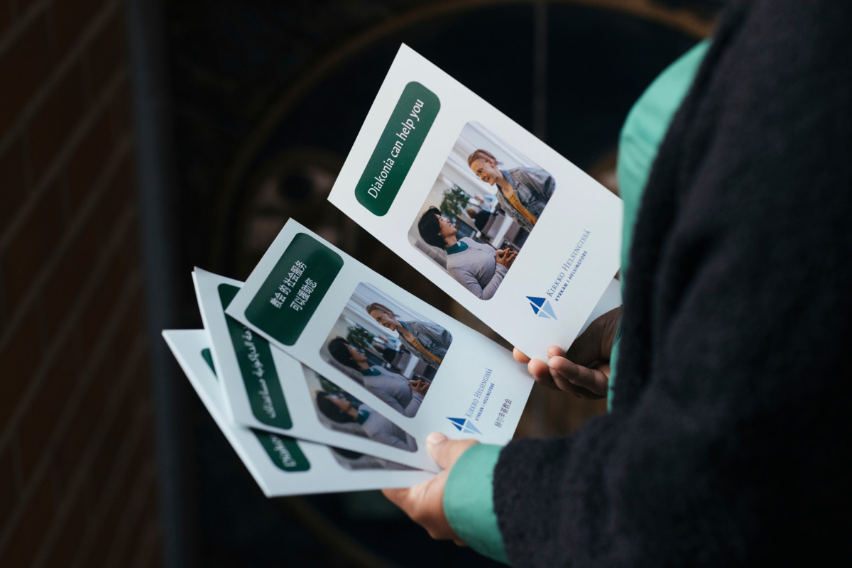 Diakonia tarkoittaa kirkon auttamistyötä. Martta Shiberu pitelee käsissään siitä kertovia arabian-, kiinan-, suomen- ja englanninkielisiä esitteitä.