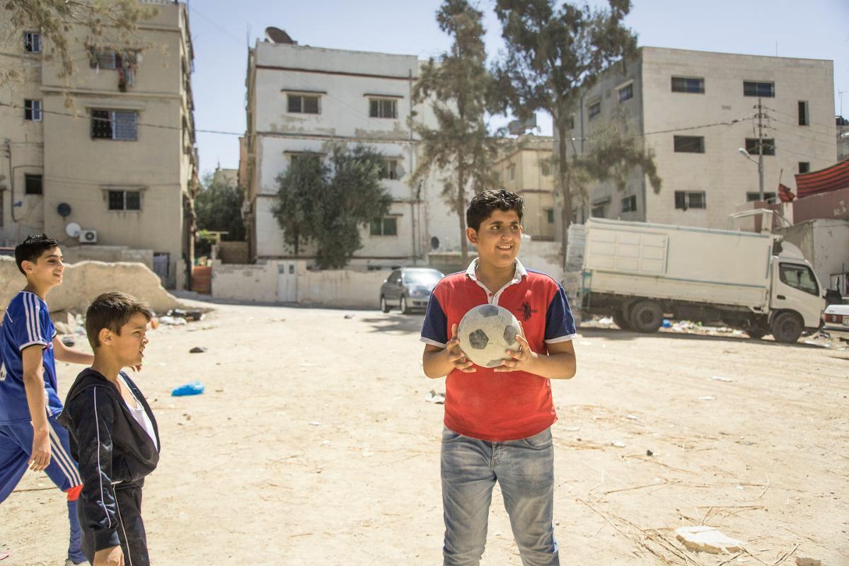 Mohamed pelaa jalkapalloa pakolaisleirillä Jordaniassa.