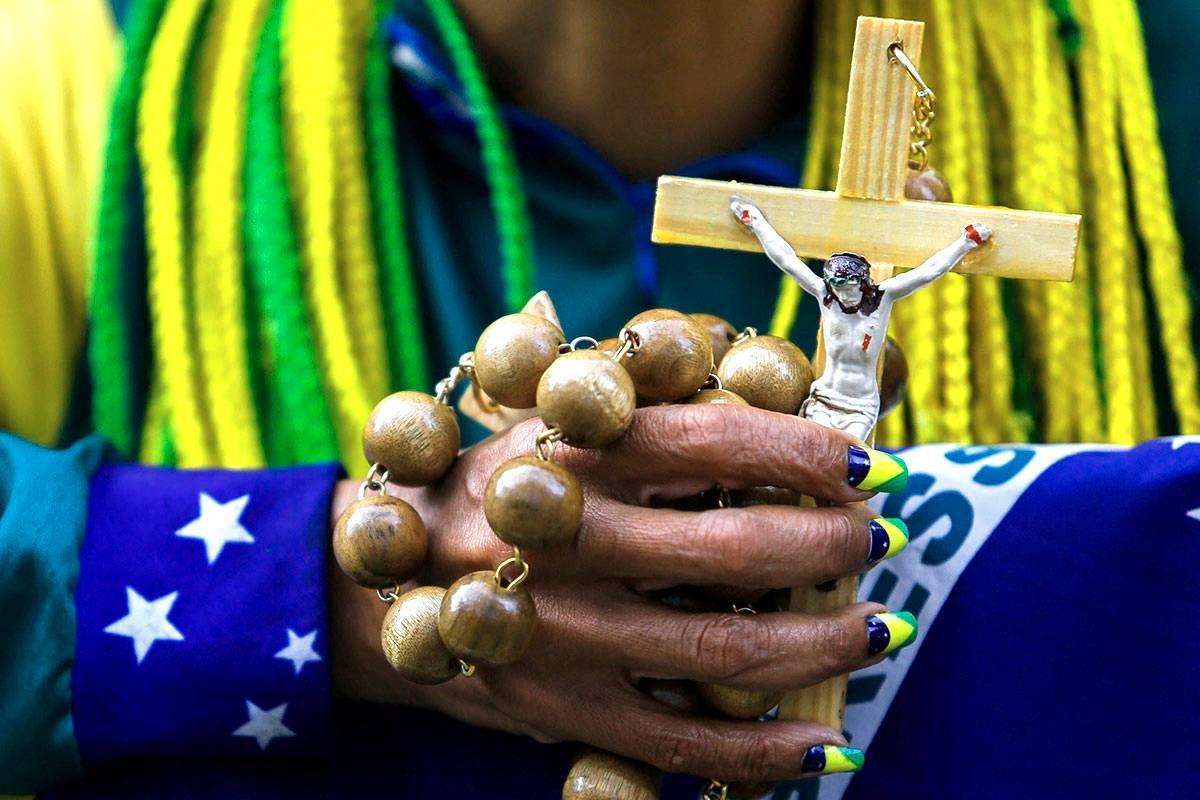 Brasiliainen fani rukoilee ennen Saksa-ottelua jalkapallon vuoden 2014 maailmanmestaruuskisoissa. Kuva: Miguel Schincariol / AFP / Lehtikuva