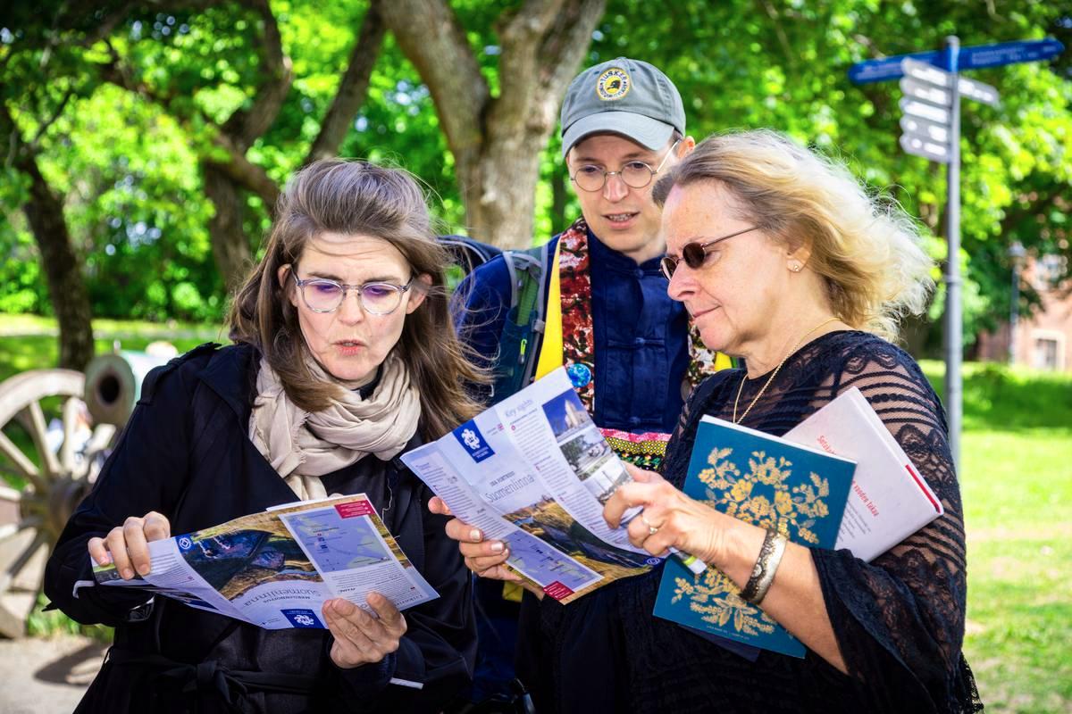 Maika Vuori (vas.), Mikko Ijäs ja Sari Näre etsivät seuraavaa kohdetta kartasta.