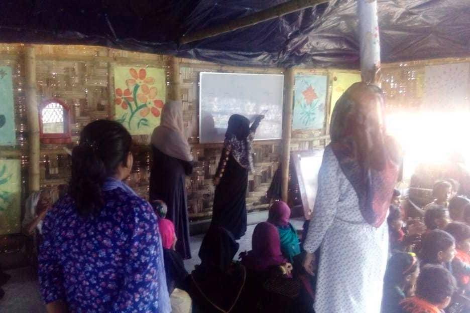 Naiset ja tytöt opettelevat lukemista ja laskemista Jamtolin pakolaisleirissä.
