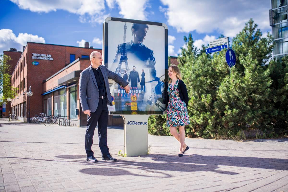 Kirkkoherra Janne Silvastia ja projektikoordinaattori Soili Pohjalaista naurattaa, kun Silvast peittää elokuvamainoksen tekstistä kaksi kirjainta. Mahdoton muuttuu mahdolliseksi.