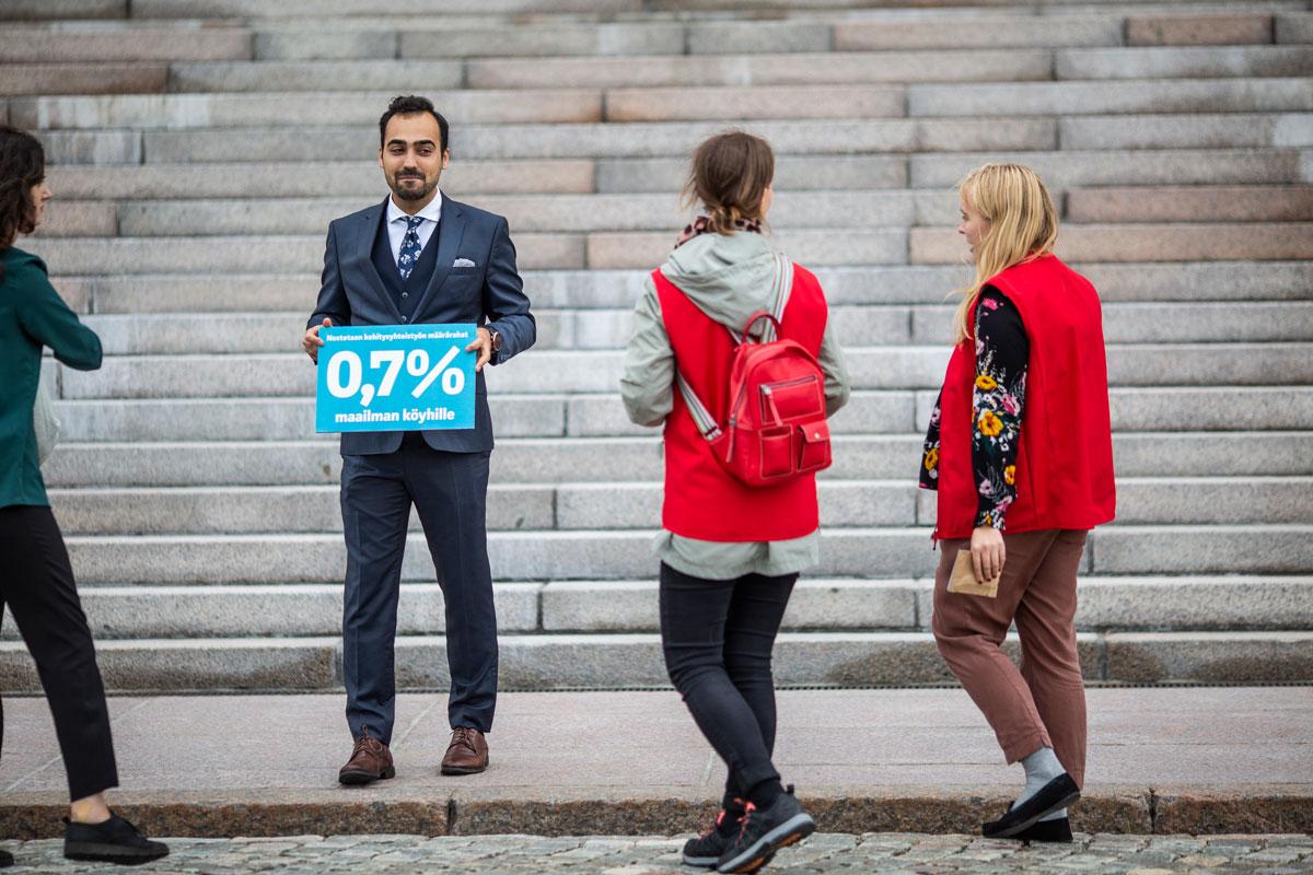 Vihreiden Ozan Yanar otti käteensä kyltin Suomen Lähetysseuran Minna Havuselta ja Sanna Raita-aholta.